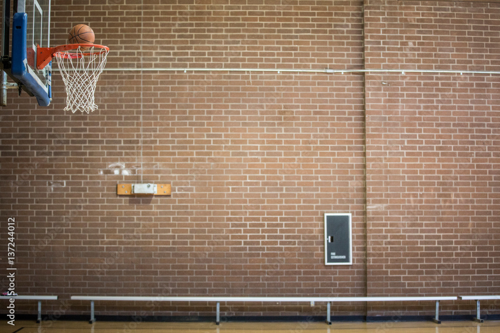 Basketball about to drop through basketball net Basketball about to drop through basketball net