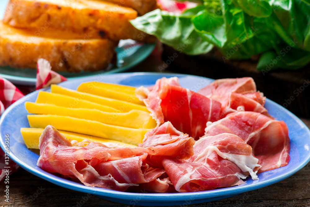 Prosciutto and mango.selective focus. Prosciutto and mango.selective focus.
