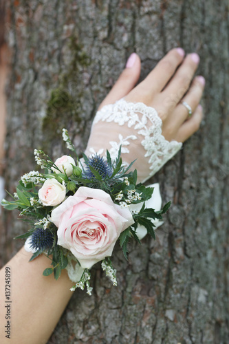 Fotografia Pale pink, blue and green wrist corsage on a hand