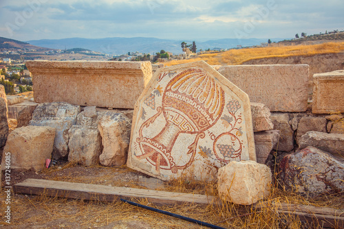 An old Roman mosaic with wine jar and grape in city of Jerash, Jordan photo