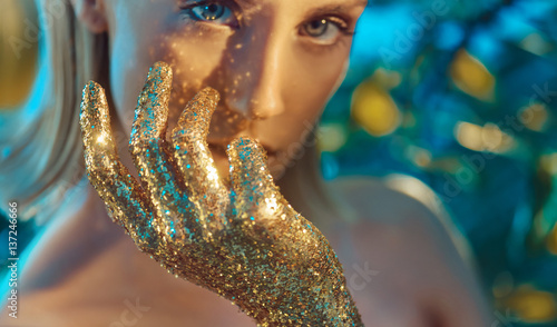 Fotografie Pretty blond woman with golden, glittering hands