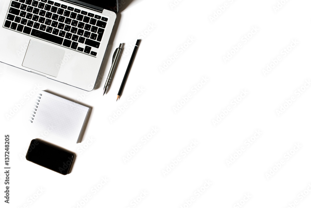 Empty copyspace in right corner and center. Minimalistic workplace with laptop keyboard, smartphone, notebook, pen and pencil on white background. Flat lay Empty copyspace in right corner and center. Minimalistic workplace with laptop keyboard, smartphone, notebook, pen and pencil on white background. Flat lay