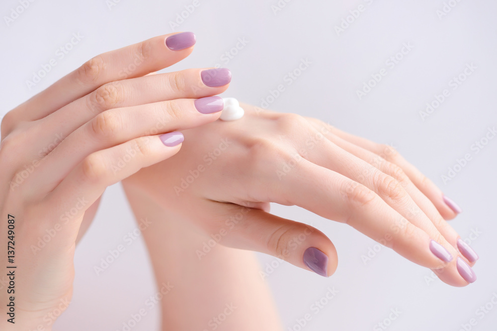 Hands of a woman with pink manicure on nails and pink flowers Hands of a woman with pink manicure on nails and pink flowers