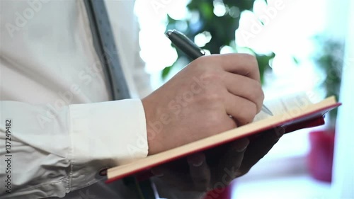 Businessman With Pen Drawing In Notepad. Close Up