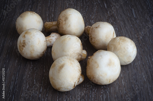 Fresh mushrooms champignons on wooden background.