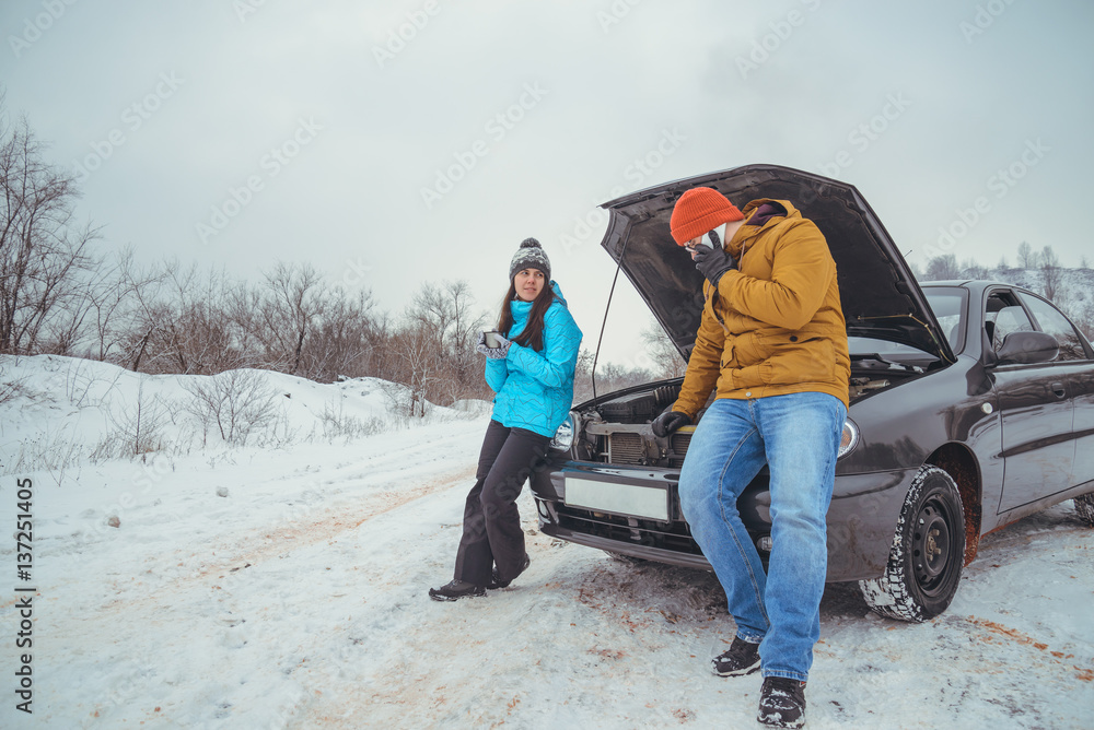 couple on the road with broken car