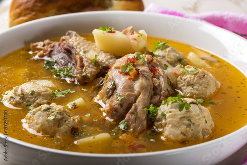 Meatballs soup with chicken meat and herbs in bowl