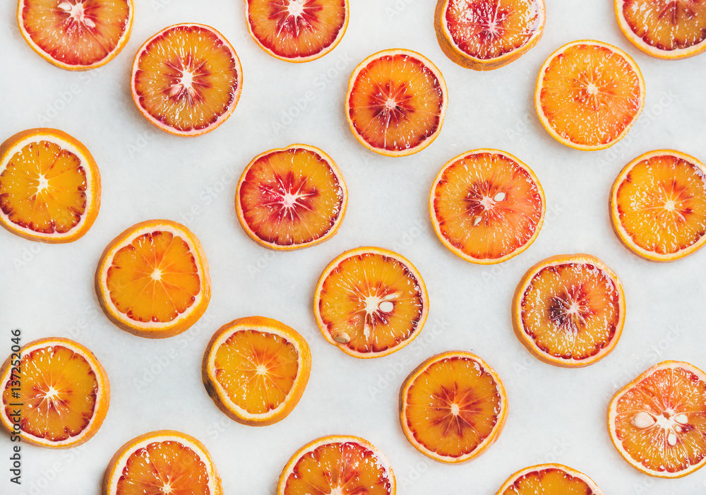 Natural fruit pattern concept. Fresh juicy blood orange slices over light marble table background, top view Natural fruit pattern concept. Fresh juicy blood orange slices over light marble table background, top view
