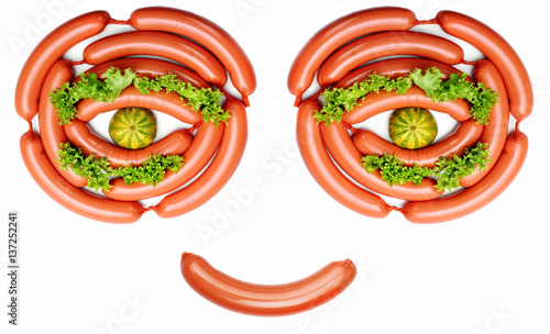 Happy smiling face from food- sausages, lashes salad, pupil mini pumkin.Concept funny food.Food art.Food emotion photo