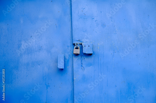 Big metal door blue dark paint and dark lock. © fortsite