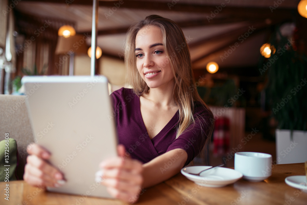 Young girl using 4g on tablet in cafe. Young girl using 4g on tablet in cafe.