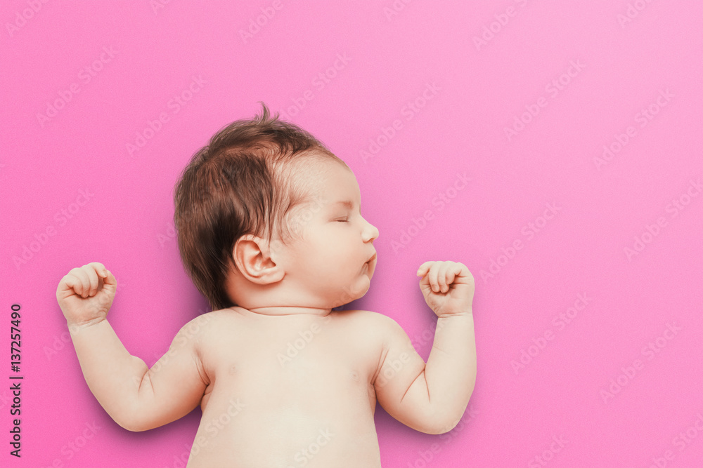 Newborn baby sleeps on pink background. Child's portrait