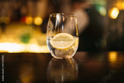 Beverage with slice of lemon and ice cubes