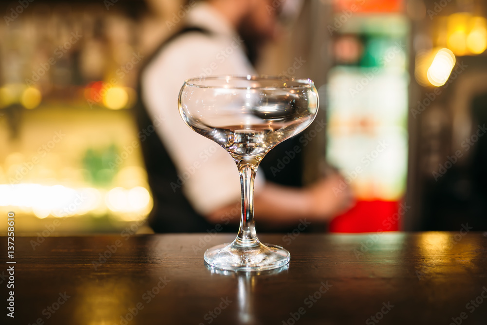 Transparent beverage in glass on bar counter Transparent beverage in glass on bar counter