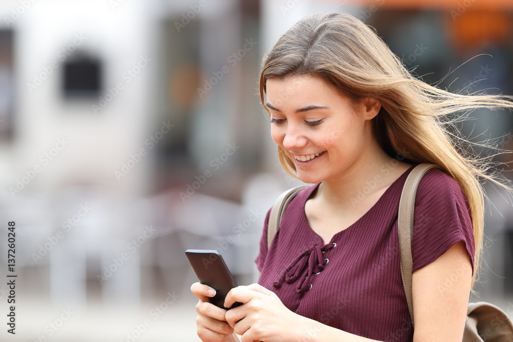 Girl walking and writing messages on phone