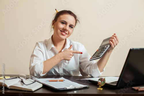 Happy young female accountant with calculator photo