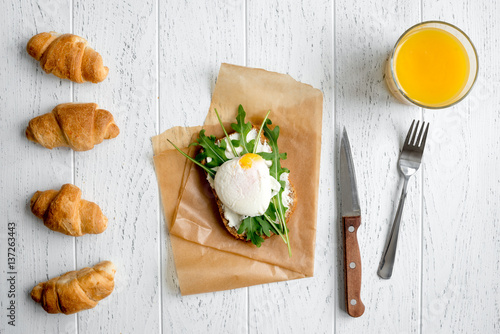 sandwich with poached eggs on wooden background top view