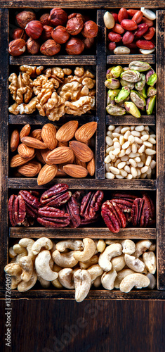 Nuts Mixed in a Wooden Vintage Box.Assortment  Walnuts Pecan Peanuts Almonds Hazelnuts Macadamia Cashews Pistachios.Concept of Healthy Eating.Vegetarian.selective focus.