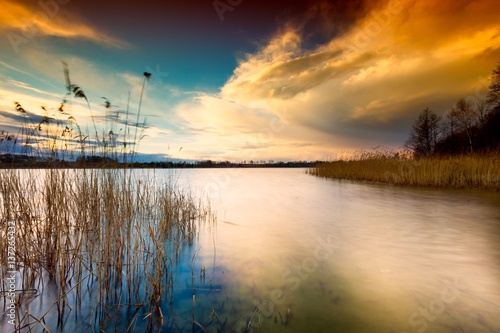 Colorful sunset sky over lake in long exposure landscape