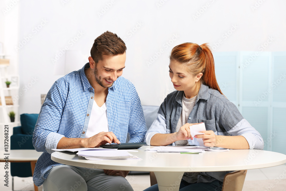 Young couple calculating taxes at home Young couple calculating taxes at home