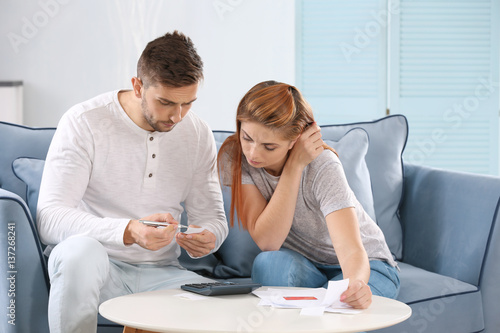 Young couple calculating ta...