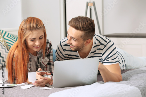 Young couple calculating ta...