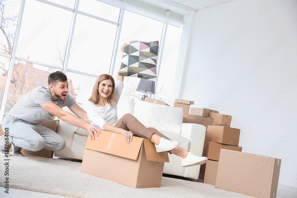 Young happy couple packing and having fun. Moving concept Young happy couple packing and having fun. Moving concept
