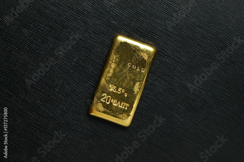 The gold bar put on the dark surface background scene represent gold and business finance concept related idea.