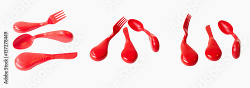 Set of red plastic ergonomic eating utensils: knife, fork and spoon. isolated.