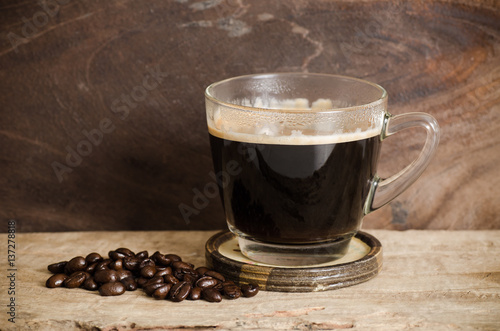 Cup of hot coffee with roasted coffee bean on wooden background