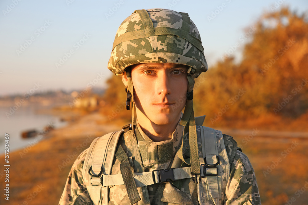 Portrait of soldier in camouflage at sunset