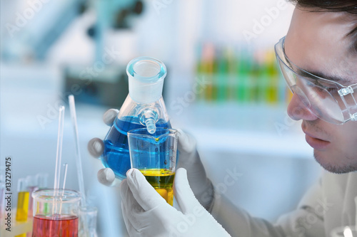 Young male scientist making...