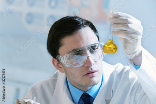 Young male scientist making...