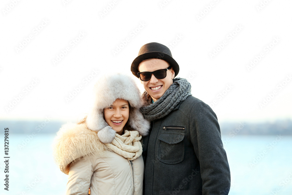 Young couple embracing on blurred river background
