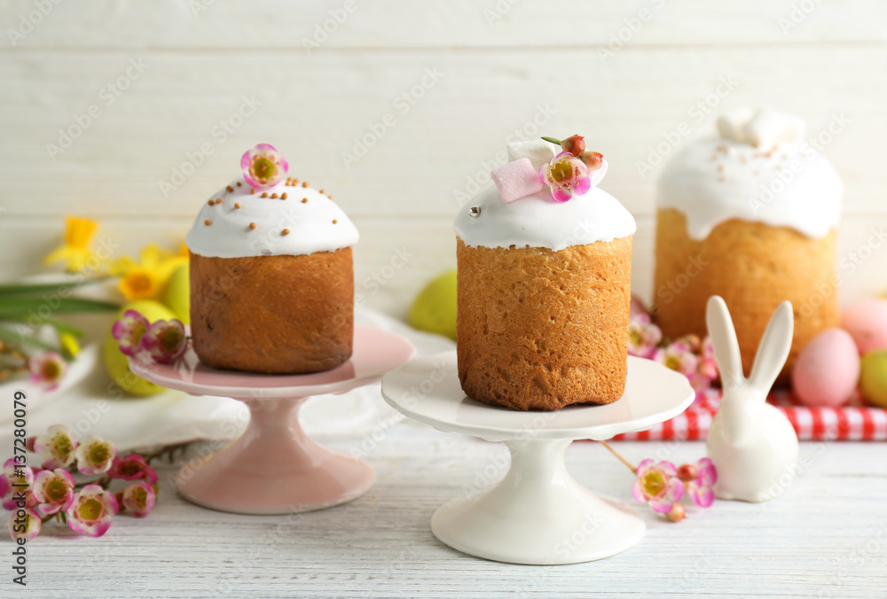 Stands with Easter cakes on wooden table Stands with Easter cakes on wooden table