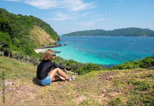 Young girl sits on a cliff,The mountains and sea scenery with blue sky,Islands: Lord Loughborough ,Myanmar
