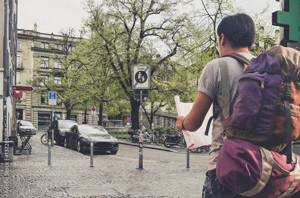 Travel concept . Asian Tourists backpack opening the map in During a trip to through Europe.