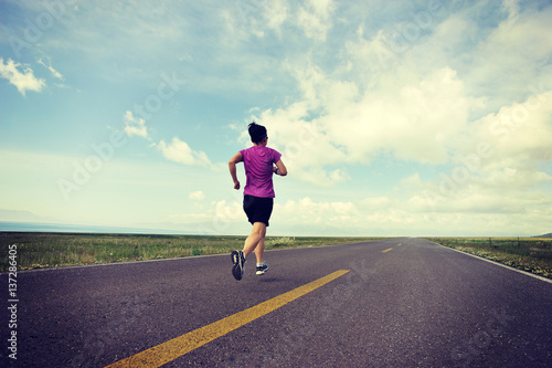 young fitness woman trail runner running on road