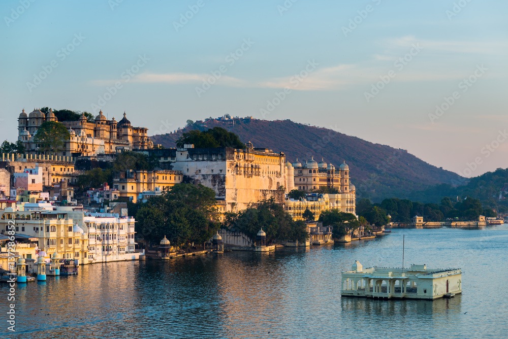 Udaipur cityscape at sunset. The majestic city palace on Lake Pichola, travel destination in Rajasthan, India