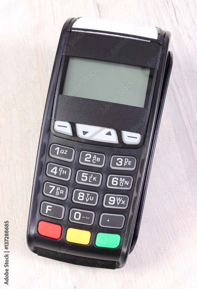 Payment terminal, credit card reader on wooden background, cashless paying for shopping, finance concept Payment terminal, credit card reader on wooden background, cashless paying for shopping, finance concept
