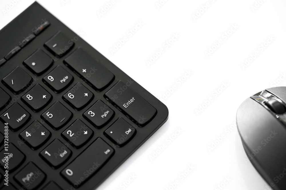 Close up shot of wireless black set mouse and computer keyboard isolated on white with copy space, focus on Enter button. Close up shot of wireless black set mouse and computer keyboard isolated on white with copy space, focus on Enter button.