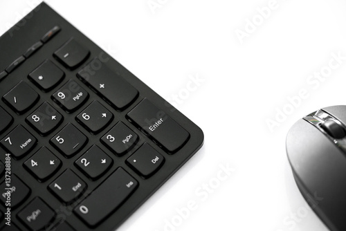 Close up shot of wireless black set mouse and computer keyboard isolated on white with copy space, focus on Enter button.