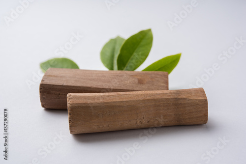 Foto Chandan or sandalwood powder with traditional mortar, sandalwood sticks, perfume or oil and green leaves
