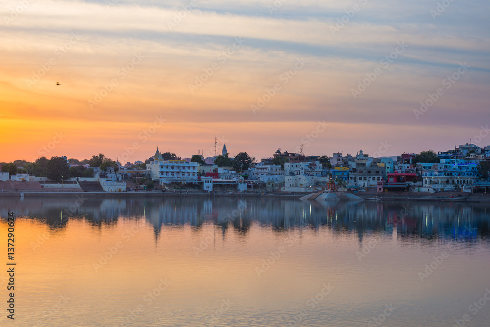 Cityscape at Pushkar, Rajasthan, India. Temples, buildings and ghats reflecting on the holy water of the lake at sunset.
