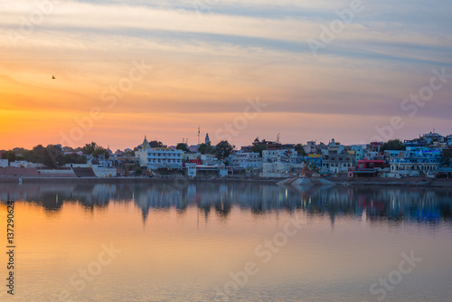 Cityscape at Pushkar, Rajasthan, India. Temples, buildings and ghats reflecting on the holy water of the lake at sunset. © fabio lamanna