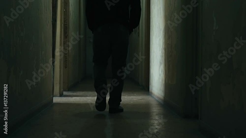 Following a hooded young man inside a dark derelict ghetto building,slow motion dramatic