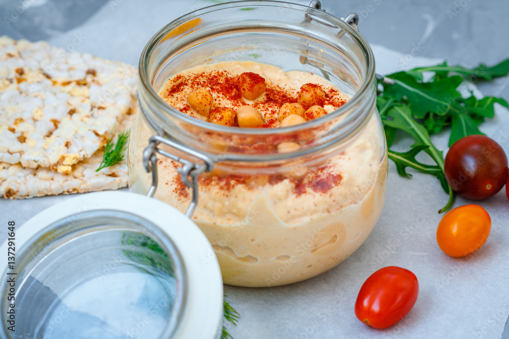 Healthy chickpea hummus in jar with vegetables. Clean eating, vegetarian, raw, detox, dieting concept Healthy chickpea hummus in jar with vegetables. Clean eating, vegetarian, raw, detox, dieting concept