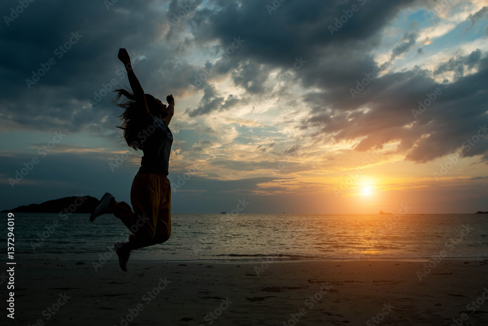 Fototapeta premium silhouette women jumping on the beach seaside.