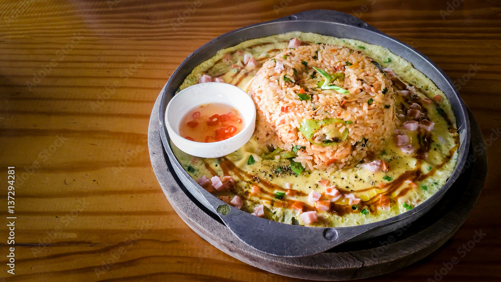 spicy fried rice ( Tom Yum ) seafood with mixed vegetable and cheese in cast iron pan spicy taste at Thai styled food spicy fried rice ( Tom Yum ) seafood with mixed vegetable and cheese in cast iron pan spicy taste at Thai styled food
