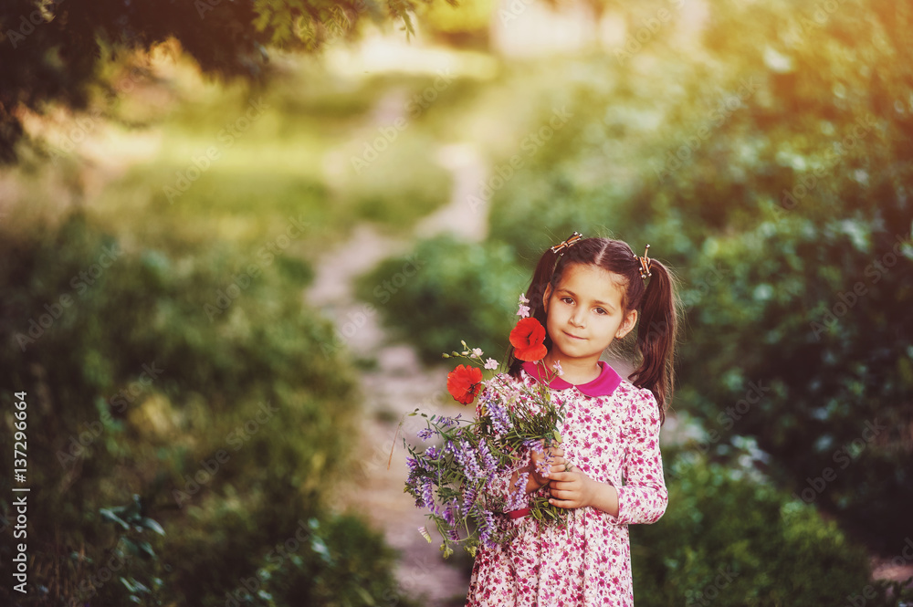 girl with flowers walks in the summer forest